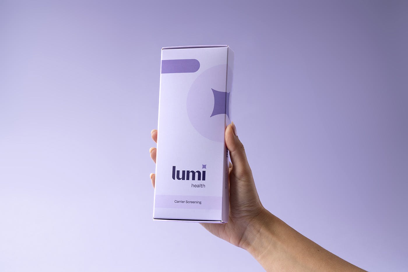 a hand holding up a Lumi carrier screening kit